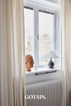 a lamp sitting on top of a window sill next to a radiator