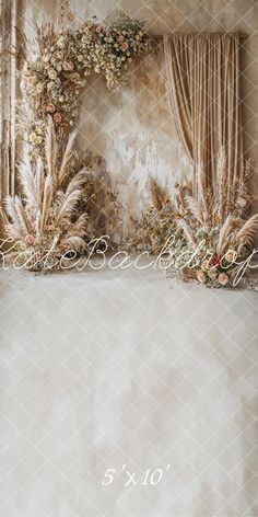 an arrangement of flowers and greenery on a window sill in front of curtains