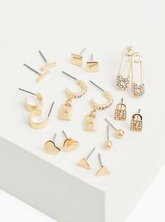 A collection of stud earrings with safety pins, heart designs, and locks in stud styles. Set of 9 . Post backs. Base metal. Imported. The best plus size women's gold-tone rhinestone safety pin stud & huggie hoop earrings set - of 9 sets in gold. Torrid is your destination for cozy fall and winter clothes to keep you warm and comfortable. Heart Designs, Stud Style, Fitted Wedding Dress, Safety Pins, Hoop Earring Sets, Huggie Hoop Earrings, Cozy Fall, Bra Cups, Safety Pin