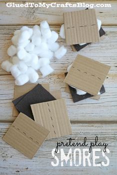 several pieces of cardboard sitting next to cotton balls on top of a wooden table with text overlay that says, pretend play smore's