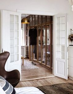 an open door leading into a bedroom with white walls and wood flooring on the other side