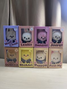 four little stuffed animals in boxes on a table