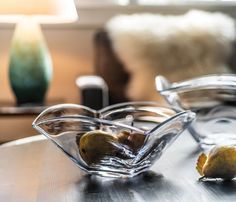 two pears in a glass bowl on a table