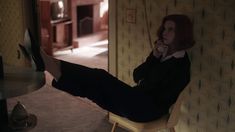 a woman sitting in a chair talking on a cell phone