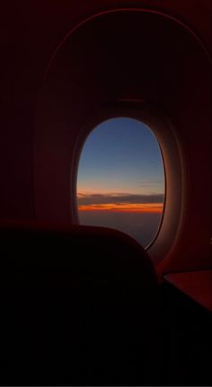 an airplane window looking out at the sunset