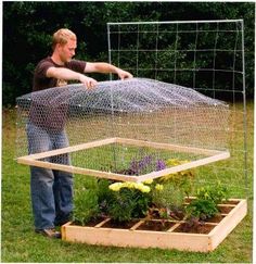 a man standing in front of a chicken coop with plants growing out of the top