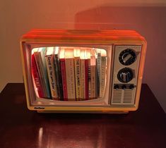 an old fashioned television with books in it