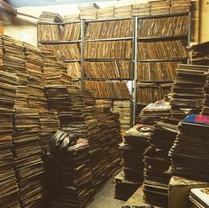 stacks of books are stacked on top of each other in a room with metal bars