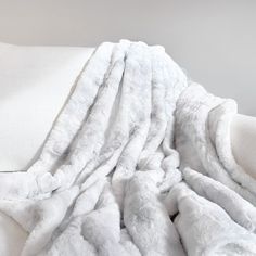 a white blanket sitting on top of a couch