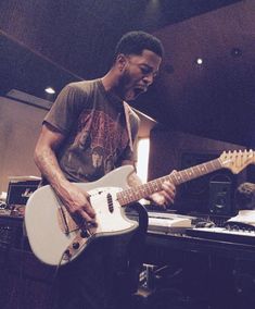 a man playing an electric guitar in a recording studio