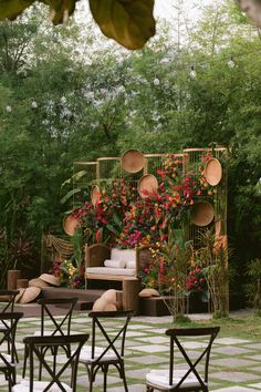 an outdoor seating area with chairs, tables and potted plants on the side wall