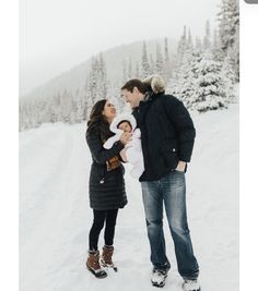 a man and woman are standing in the snow