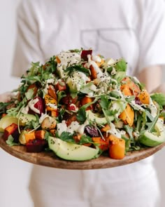 a person holding a plate with salad on it