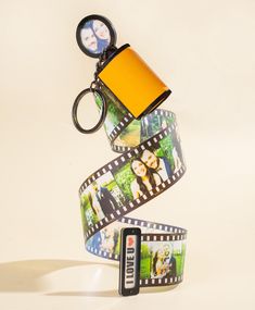 a camera strap with pictures on it and a keychain hanging from the end