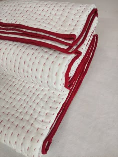 two red and white bedspreads on top of each other