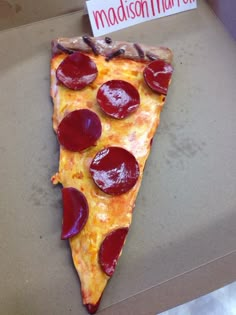 a slice of pizza with pepperoni and cheese on it sitting in a cardboard box