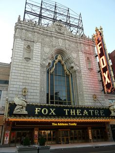 the fox theatre sign is lit up in front of it's entrance and windows