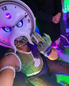 a woman in a costume with a clock on her face