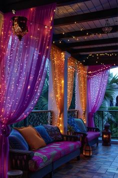 an outdoor seating area with purple curtains and lights