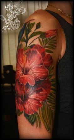 a woman's arm with flowers and leaves on it