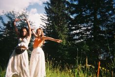 two women in white dresses are posing for the camera