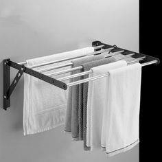 a towel rack with towels hanging from it's sides and two pairs of pants hanging on the rails