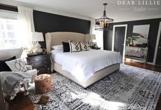 a bedroom with black walls and white bedding in the center, along with an area rug on the floor