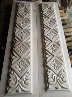 two white wooden doors with intricate designs on the front and back sides, sitting next to each other