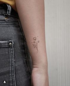 a woman's arm with a small flower tattoo on the left side of her right arm