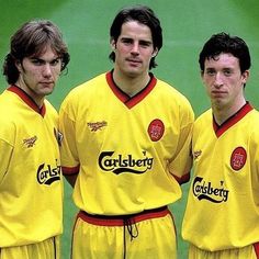 three men in yellow soccer uniforms standing next to each other