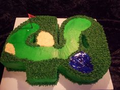 a golf themed birthday cake with green grass and blue icing on it's side