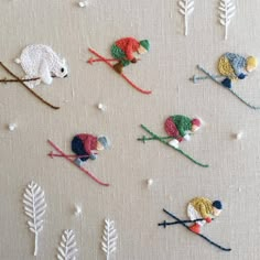 several crocheted mice are on skis and snowflakes in the background