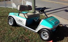 a blue and silver golf cart parked on the side of the road next to an orange fire hydrant