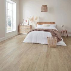 a bedroom with white walls and wood floors