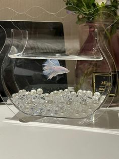 there is a fish bowl with pearls in it