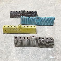 four different colored concrete blocks sitting on the ground