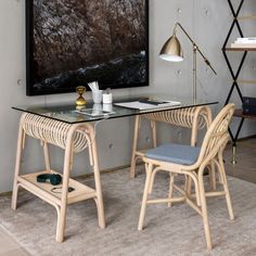 a desk with two chairs and a painting on the wall