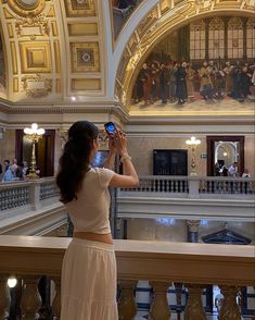 a woman taking a photo in the middle of a building