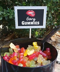 gummy bears in a black bucket with a sign on the side saying gory gummies