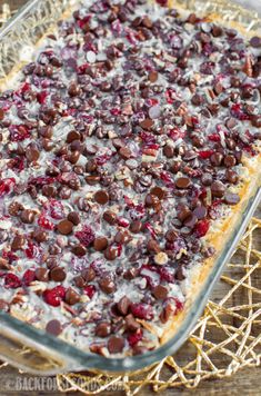 a casserole dish with cranberries and nuts on top