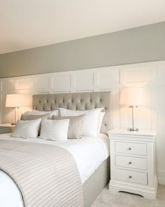 a bedroom with a bed, nightstands and two lamps on either side of the bed