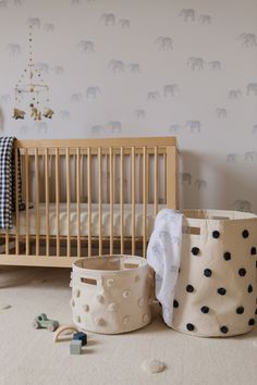 a baby's room with an elephant wallpaper and crib bedding in the background