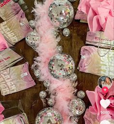 disco balls and pink feathers are on the floor next to other party items, including tissue bags