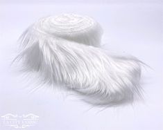 the white fur is laying on top of each other in front of a white background