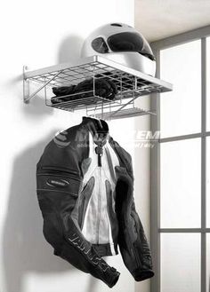 a motorcyclist's jacket and helmet hanging from a rack in a room