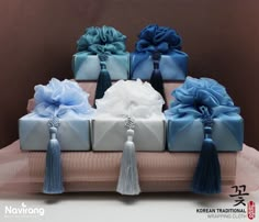 a group of blue and white gift boxes with tassels