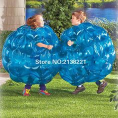 two children with large blue inflatable balls on their backs, one is holding the other