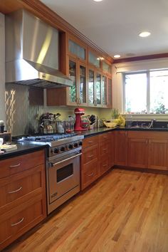 a kitchen with wooden floors and stainless steel appliances