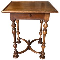 an old wooden table with turned legs and a drawer on the top, isolated against a white background