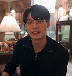 a young man wearing glasses in a living room